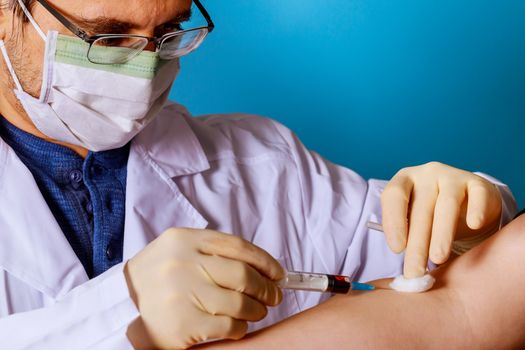 Closeup of doctor taking a blood sample from arm vein