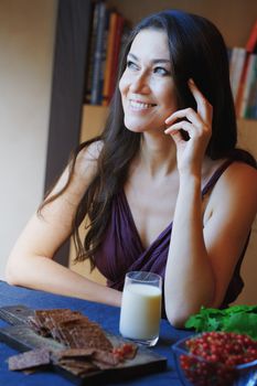 Vegan woman sitting at the table with healthy food