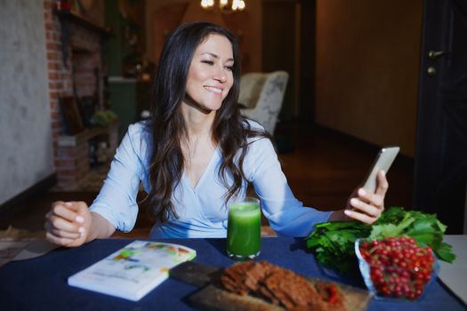 Woman at the table with healthy food making mobile photo selfie for her Internet blog