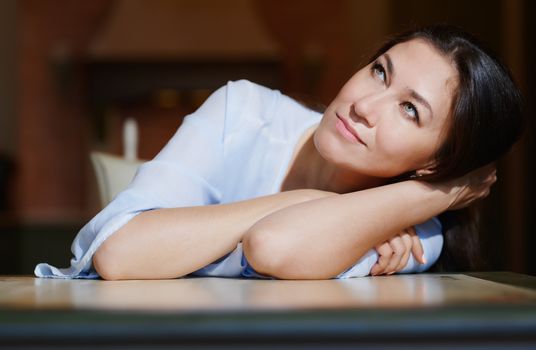 Serious staying at home woman laying on the table