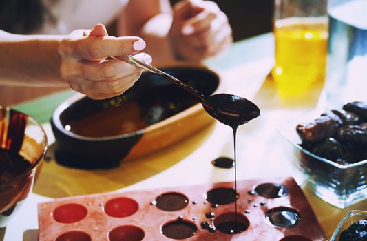 Staying at home woman preparing handmade vegetarian chocolate truffles