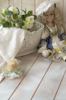 vintage porcelain doll in the shabby table. Porcelain doll in vintage interior.