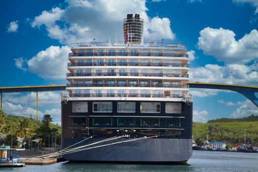 Luxury blue and white cruise ship moored beside bridge in Curacao