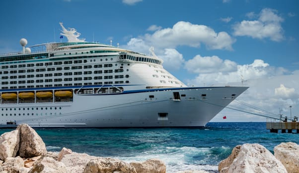 Luxury cruise ship beyond rock sea wall in Curacao