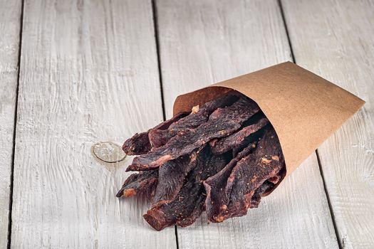 Jerky in a paper bag on top on white table