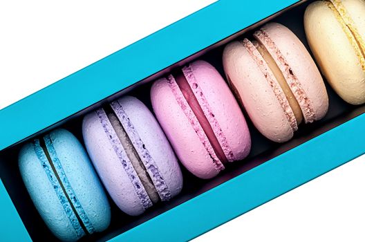 Macaroons in box top view on white background