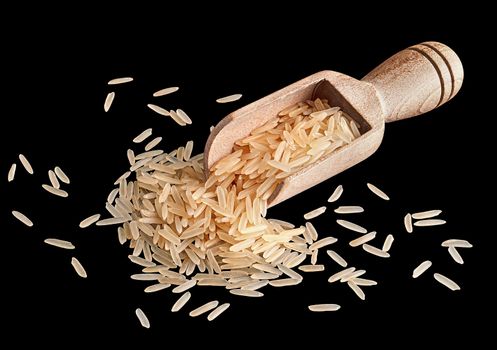 Long rice in wooden scoop on black background