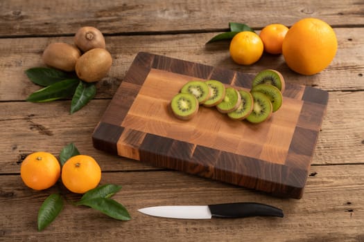 Juicy whole and sliced fruit with a knife on a wooden cutting board