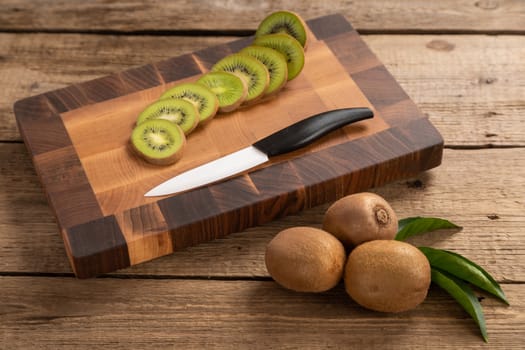 Juicy green kiwi sliced on wooden carving board