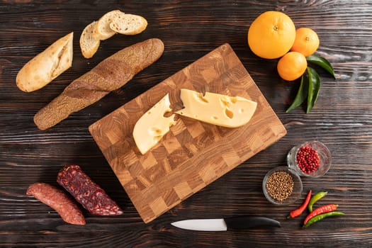 Sausage, cheese and bread on wooden cutting board