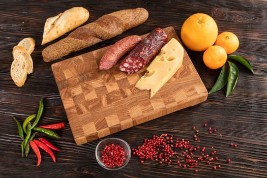 Sausage, cheese and bread on wooden cutting board