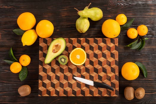 Juicy whole and sliced fruit with a knife on a wooden cutting board