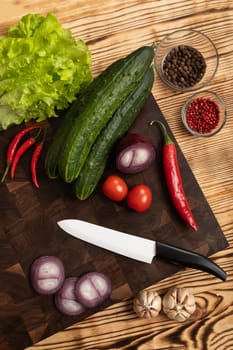 Fresh vegetables and greens on wooden cutting board