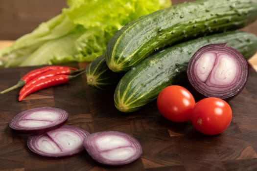 Fresh vegetables and greens on wooden cutting board