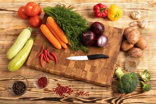 Fresh vegetables and greens on wooden cutting board