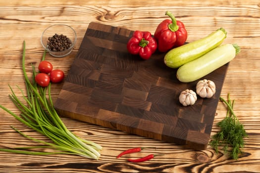 Fresh vegetables and greens on wooden cutting board