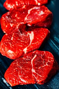 Beef steaks on cutting board close up