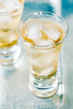 Beverage with ice cubes in glass.