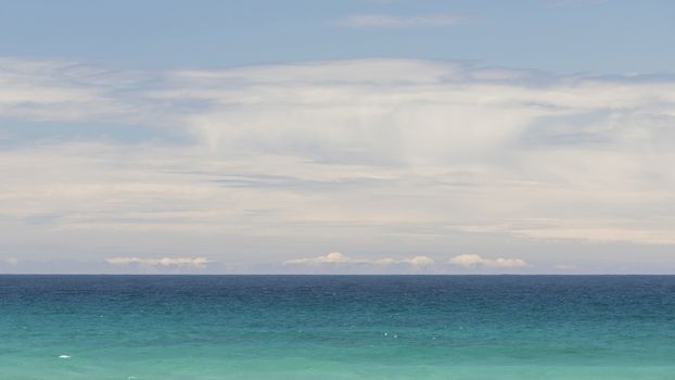 Minimalist seascape with turquoise waters and cloudy sky