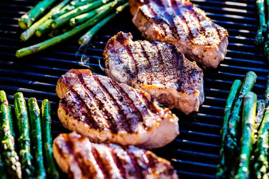 Pork chops and asparagus on grill close up
