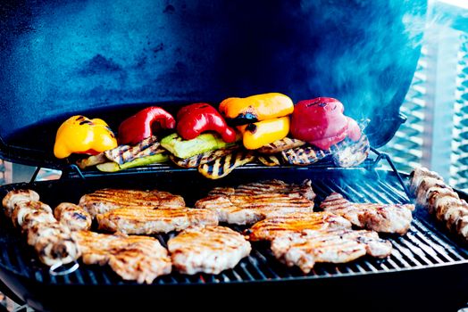 Assorted vegetables and meat cooking on a grill
