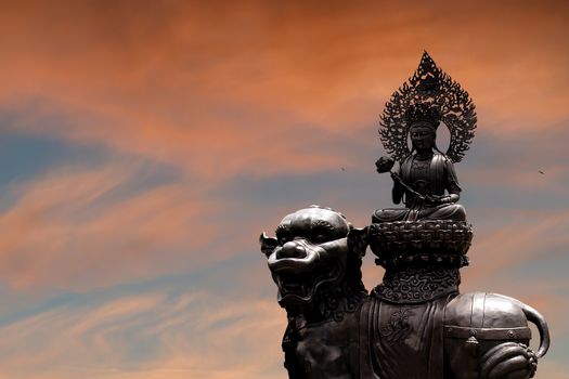 The silhouette of the Buddha statue against the sunset sky. The concept of congratulations from the Buddhist celebration of Buddha's birthday, called Vesak day, Buddhist lent, the Buddha's birthday, the worship of Buddha Purnima. Copy space for your design.