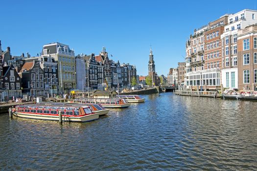 City scenic from Amsterdam with the Munt tower in the Netherlands at the river Amstel