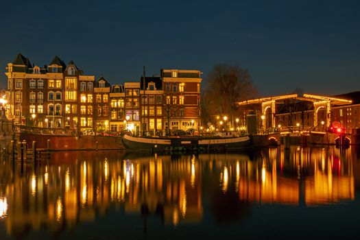 City scenic from Amsterdam at the river Amstel  in the Netherlands at night