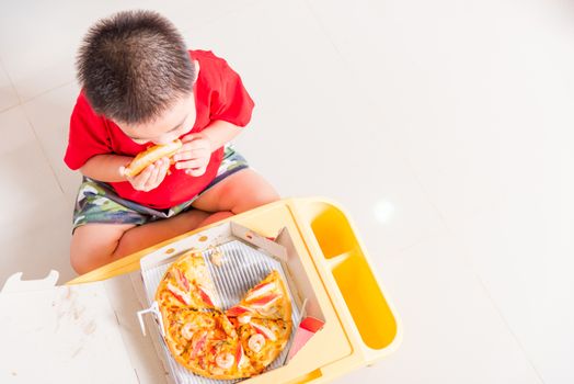 Hot Homemade, Vegetarian fast Italian food, Top view of Cute Little Child enjoying eating Delivery Pizza pepperoni, cheese many slices deliciously in a cardboard box at home with copy space for text