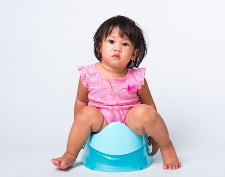 Asian little cute baby child girl education training to sitting on blue chamber pot or potty in, studio shot isolated on white background, wc toilet concept