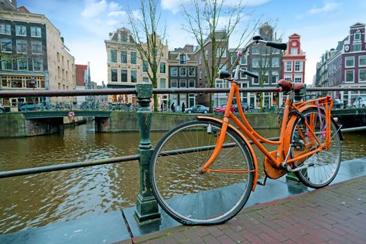 Orange bike along the canals in Amsterdam the Netherlands
