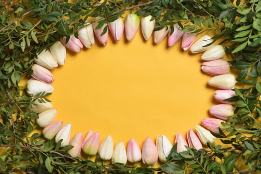 Oval frame of tulip flowers on a yellow background, template with text space. Mothers Day or March 8 holidays concept.