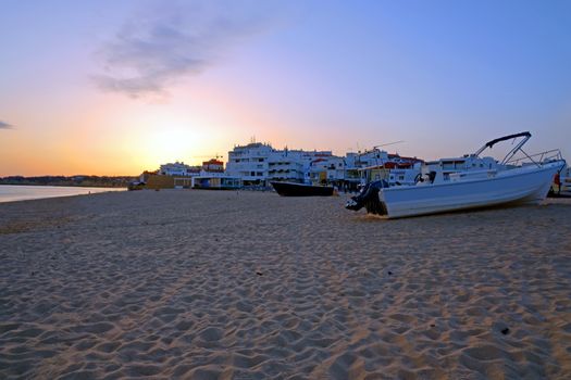 Traditional fisherman boat on the beach in Armacao de Pera at sunset