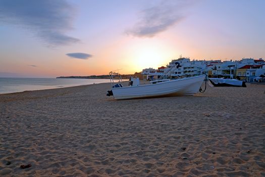 Traditional fisherman boat on the beach in Armacao de Pera at sunset