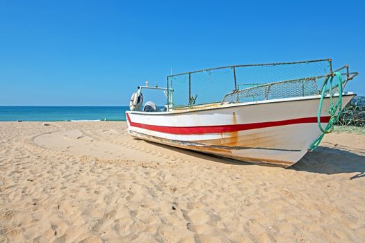 Old fishers boat on the beach in Armacao de Pera in the Algarve Portugal