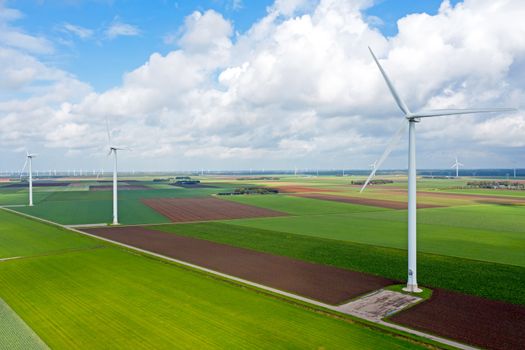 Aerial from a dutch landscape with windturbines, meadows and beautiful skies