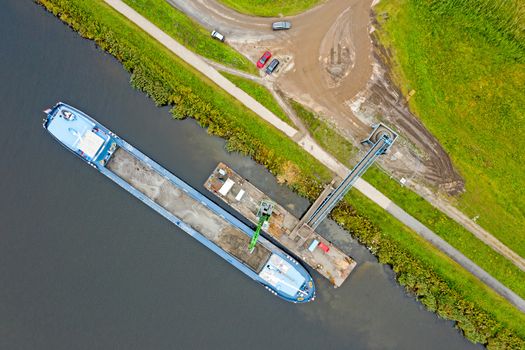 Aerial top shot from freighter unloading sand in the countryside from the Netherlands