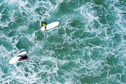 Aerial shot from surfers going to surf in the ocean