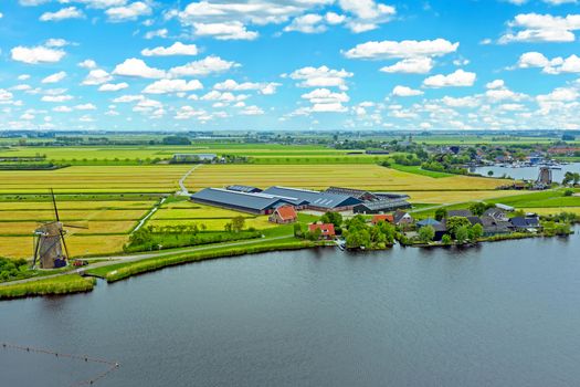 Aerial from a typical dutch landscape with windmills, water en far views. 