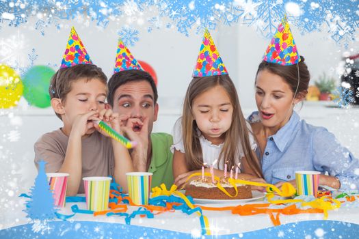 Little girl blowing her candles during her birthday party against snow