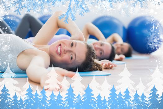 Portrait of class exercising in row at fitness studio against snow