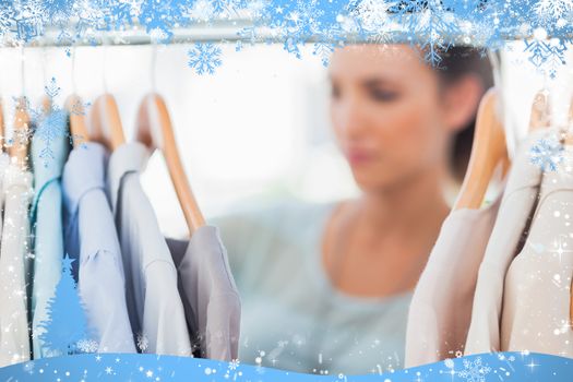 Fashion woman choosing clothes on clothes rail against snow