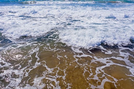 Aerial from waves on the shore at the atlantic ocean