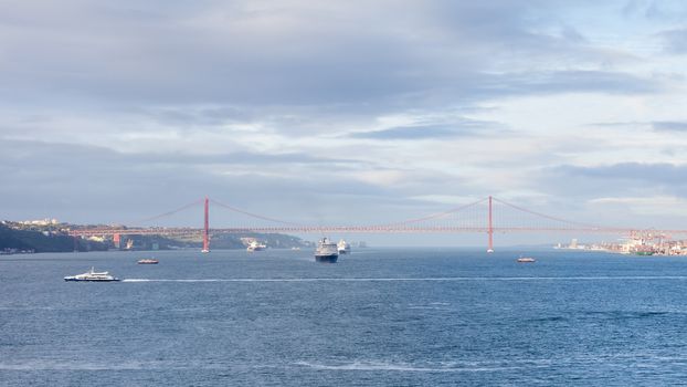 Ships and boats traverse the River Tagus beside the port of Lisbon in Portugal.