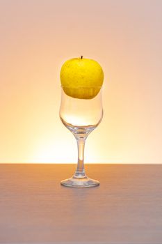 Conceptual idea of golden apple in the cider glass as raw material instead of  final product