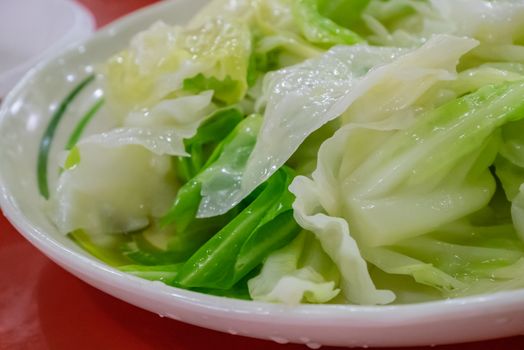 The close up of delicious stir fried cabbage on white plate at Taiwanese restaurant.