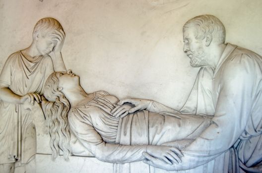 Marble frieze sculpted to show the 2nd Earl Kilmorey comforting his mistress Priscilla Anne Hoste as she lies on her deathbed in 1854 with their son David at her head.  Part of the historic Kilmorey Mausoleum, built in the 1850's and on public display in St Margarets, Twickenham, West London.  Sculptor: Lawrence MacDonald (d. 1878)