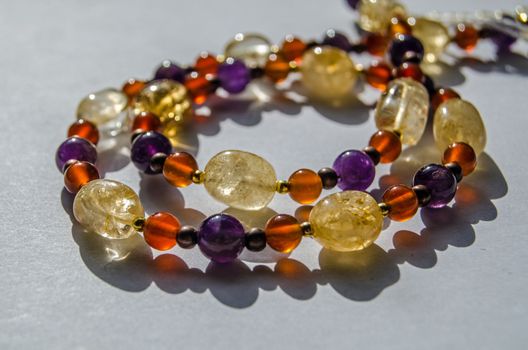 Bracelet and necklace hand made using colourful semi-precious gemstone beads including yellow citrine, purple amethyst and orange carnelian.