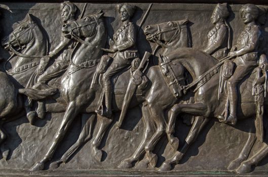Detail of the bronze frieze of soldiers riding their horses on the Cavalry Monument dedicated to those killed in World War I.  Sculpted in 1921 by Adrian Jones an on public display in Hyde Park, London.  