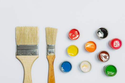 Paintbrush and a palette of paints in white background. Concept of painting, renovation, home and household chores